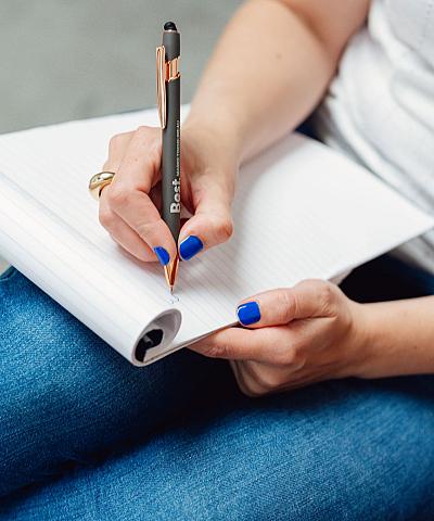 Een vrouw filmt een man in een moderne interieurshowroom. De vrouw gebruikt een gimbal om de opname stabiel te houden, terwijl de man tegenover haar staat en glimlacht.