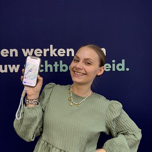Vrouw houdt smartphone met kaartweergave vast en glimlacht tegen blauwe achtergrond met tekst over zichtbaarheid.